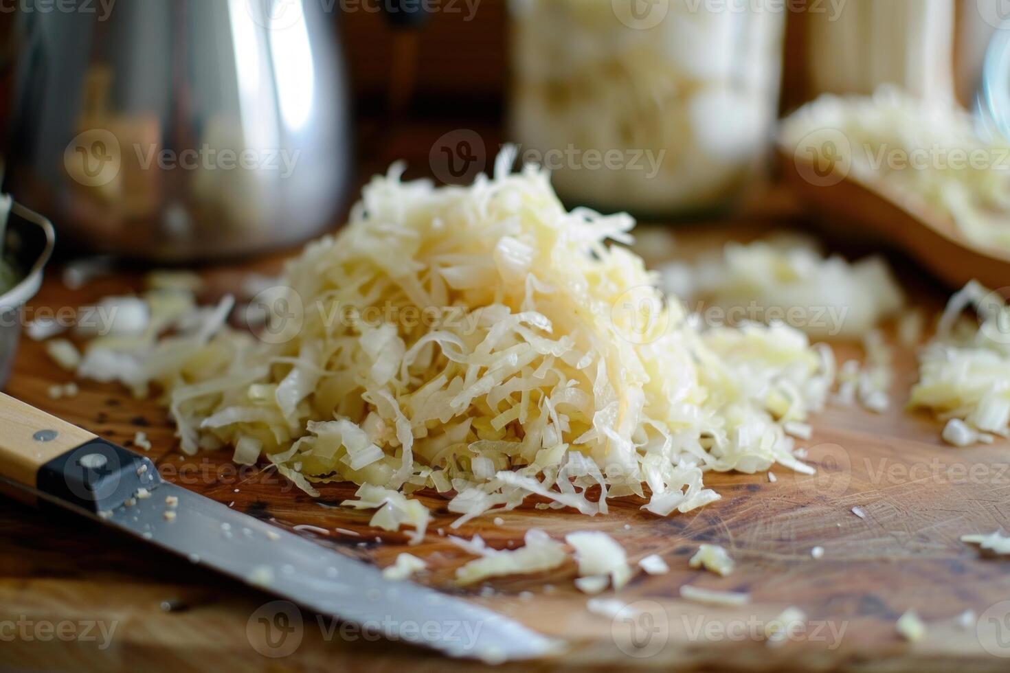 Sauerkraut on cutting board with knife and fermenting crock in background photo