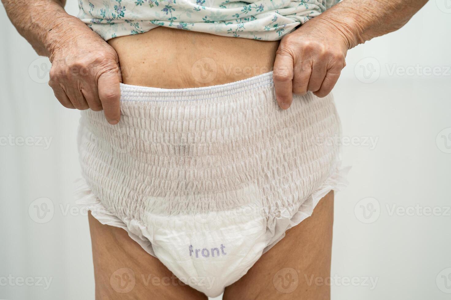 Asian senior woman patient wearing adult incontinence diaper pad in hospital. photo