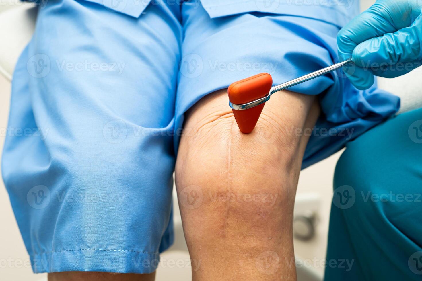 doctor knock on knee reflex nerve for check and treatment senior photo