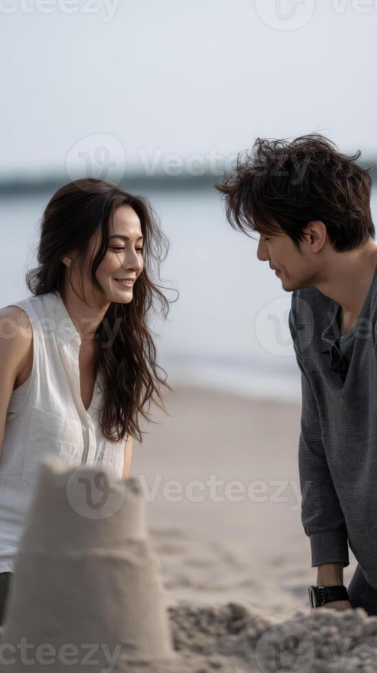 Romantic Couple Building Sandcastle on Sunny Beach photo