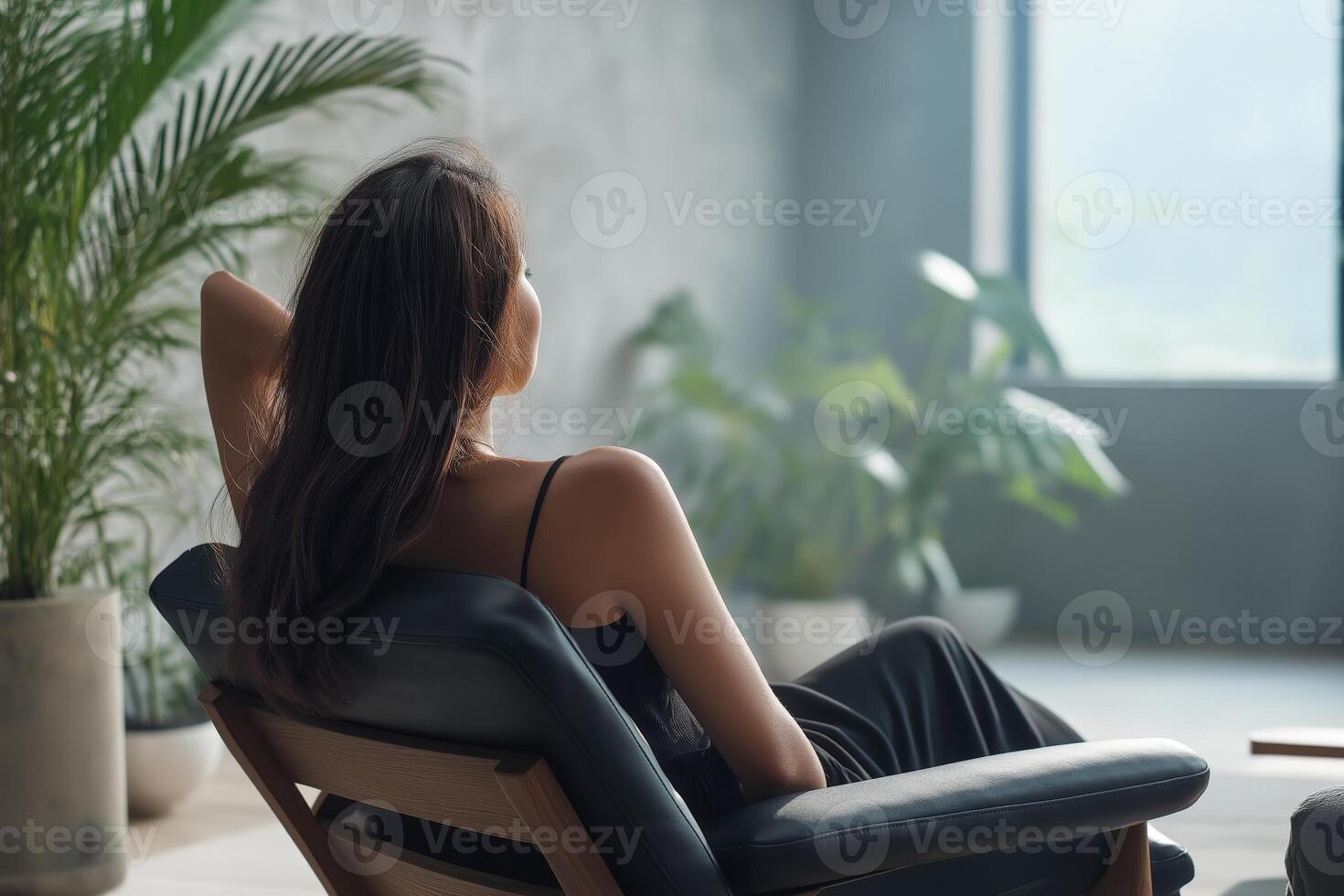 Serene Woman Relaxing in Modern Interior with Lush Greenery photo