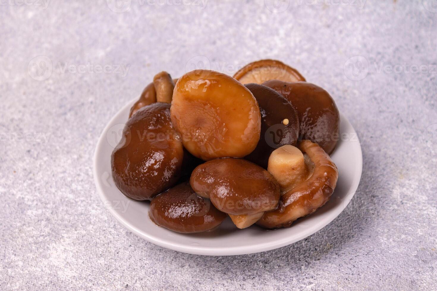 salted mushrooms lie on a white plate, on a white background, copy space photo