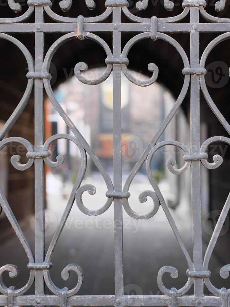 a forged lattice closes the entrance to the courtyard of the house photo