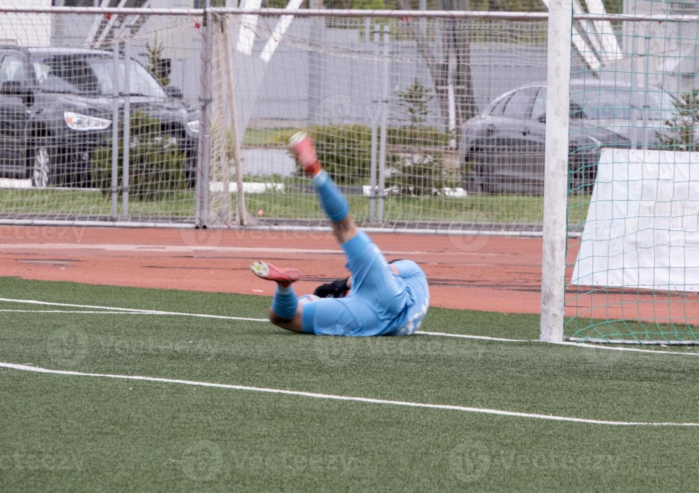 goalkeeper lying on football field after conceding goal, selective focus photo