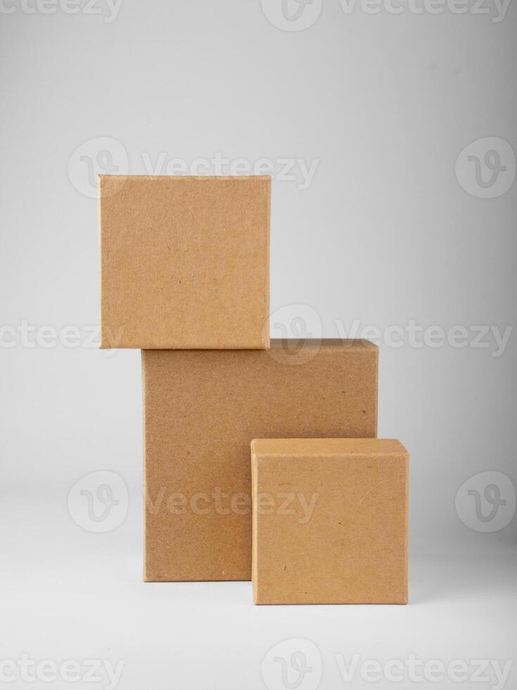 Three square cardboard boxes stand on white background, mockup photo