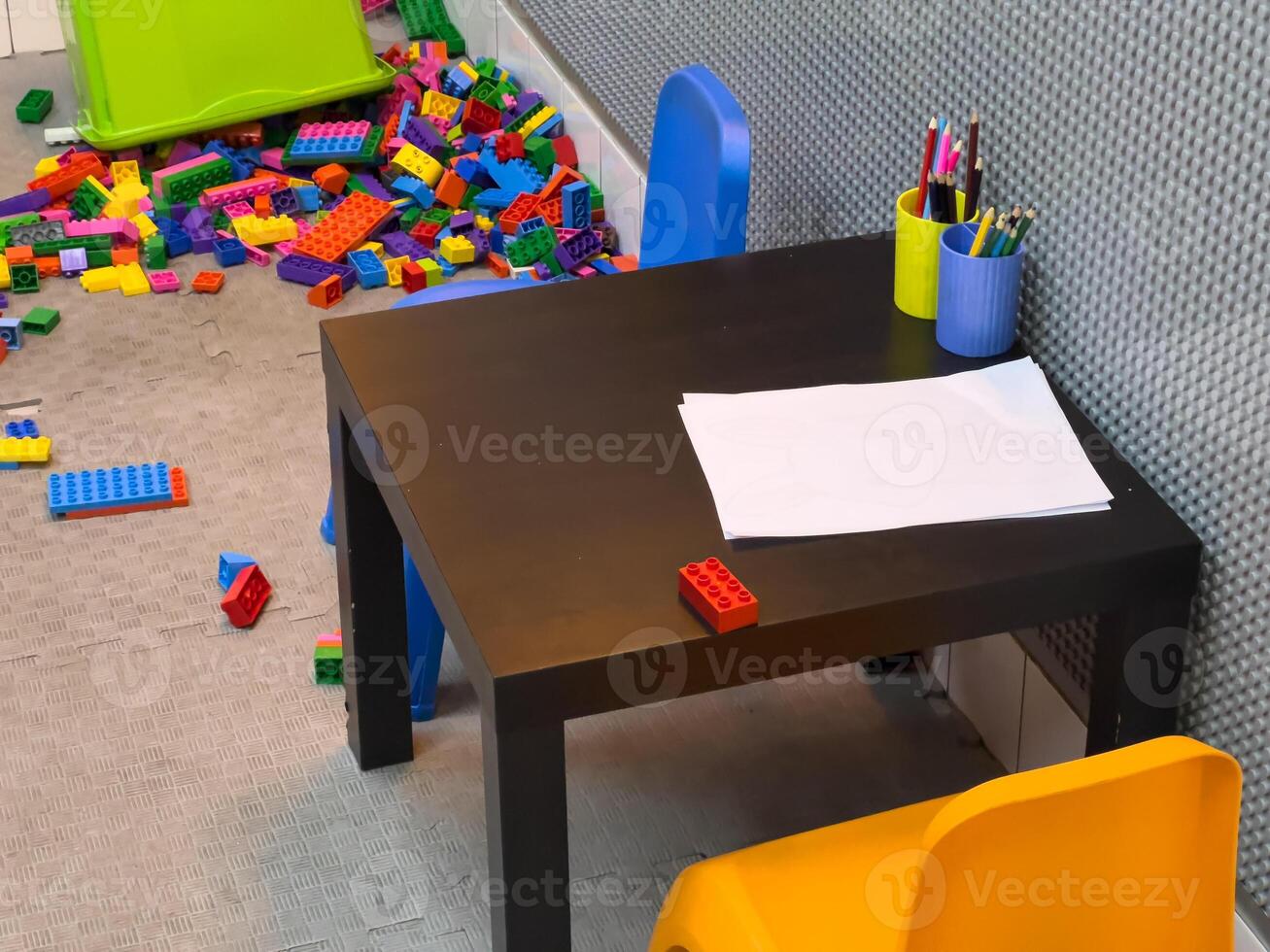 Colorful blocks are strewn across the play area, with a small table and chairs set up for creative activities nearby photo