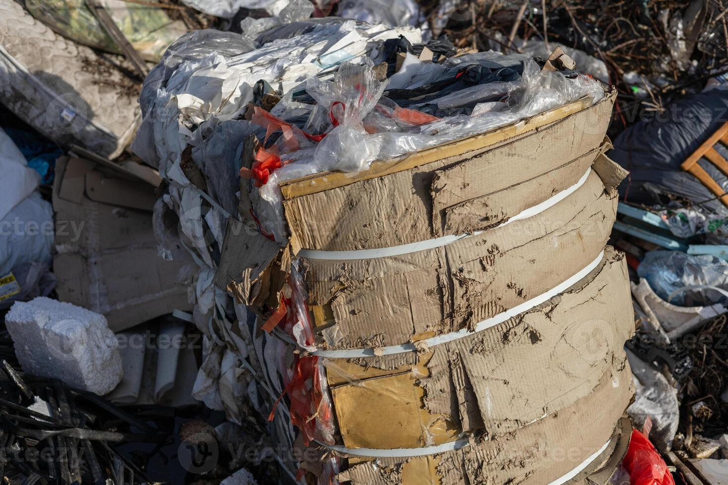 Various materials are stacked together in a recycling site, showcasing the improper disposal of waste in an urban area during daylight photo