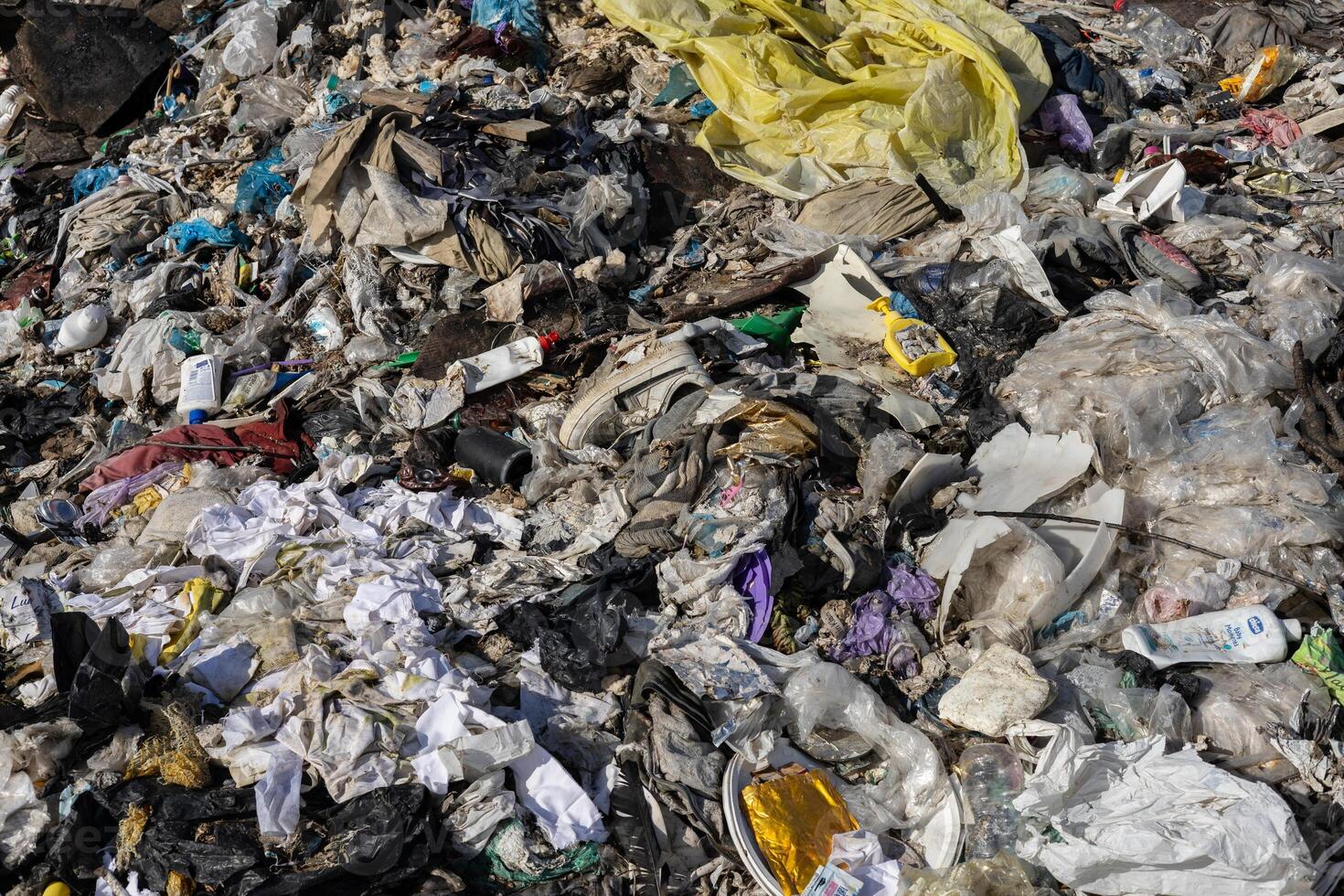 A vast pile of mixed waste accumulates, showcasing plastic and paper debris that highlights severe urban pollution problems photo