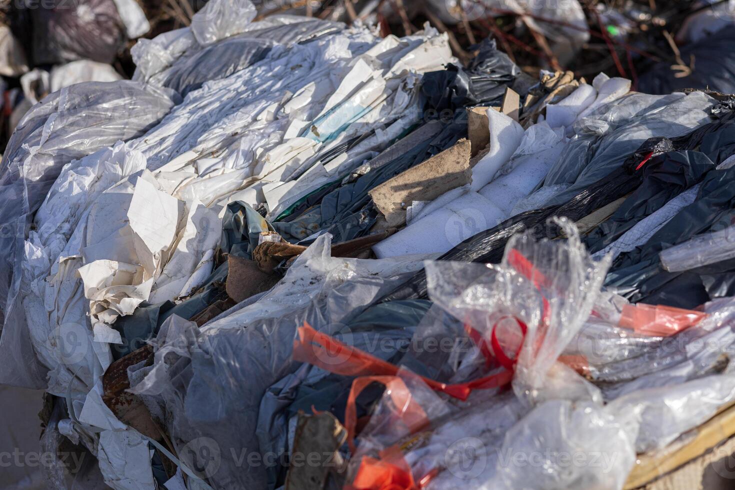 Various types of recyclable materials are stacked together at a waste management facility, showcasing the importance of recycling efforts photo