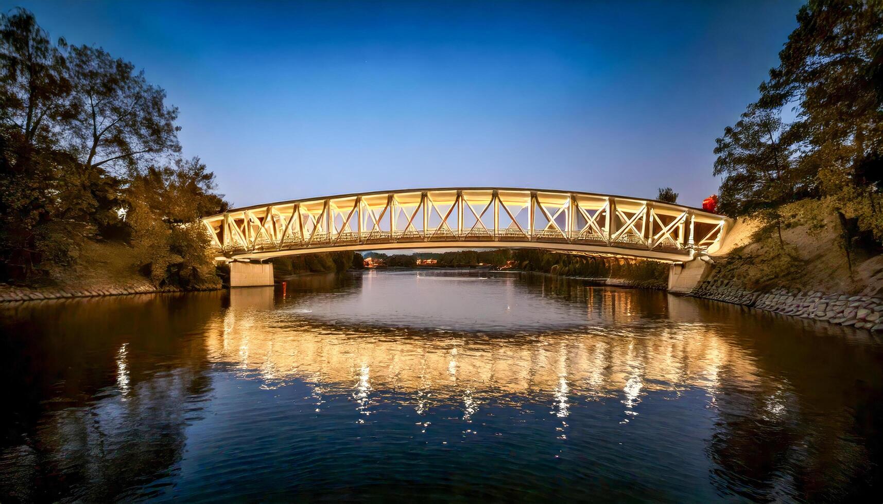 Bridge illuminated over a calm river at twilight. Lights reflect on the water. A peaceful urban scene. Explore the bridge's architecture. photo