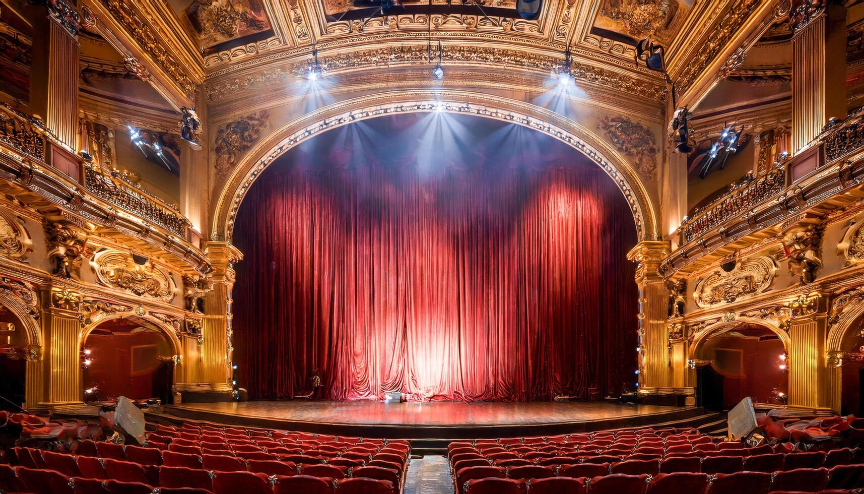 An opulent hush fills the theater as rich crimson curtains softly part. Behind them, warm gold glows like hidden treasure. Expectation crackles in the still air, waiting for the first line. photo