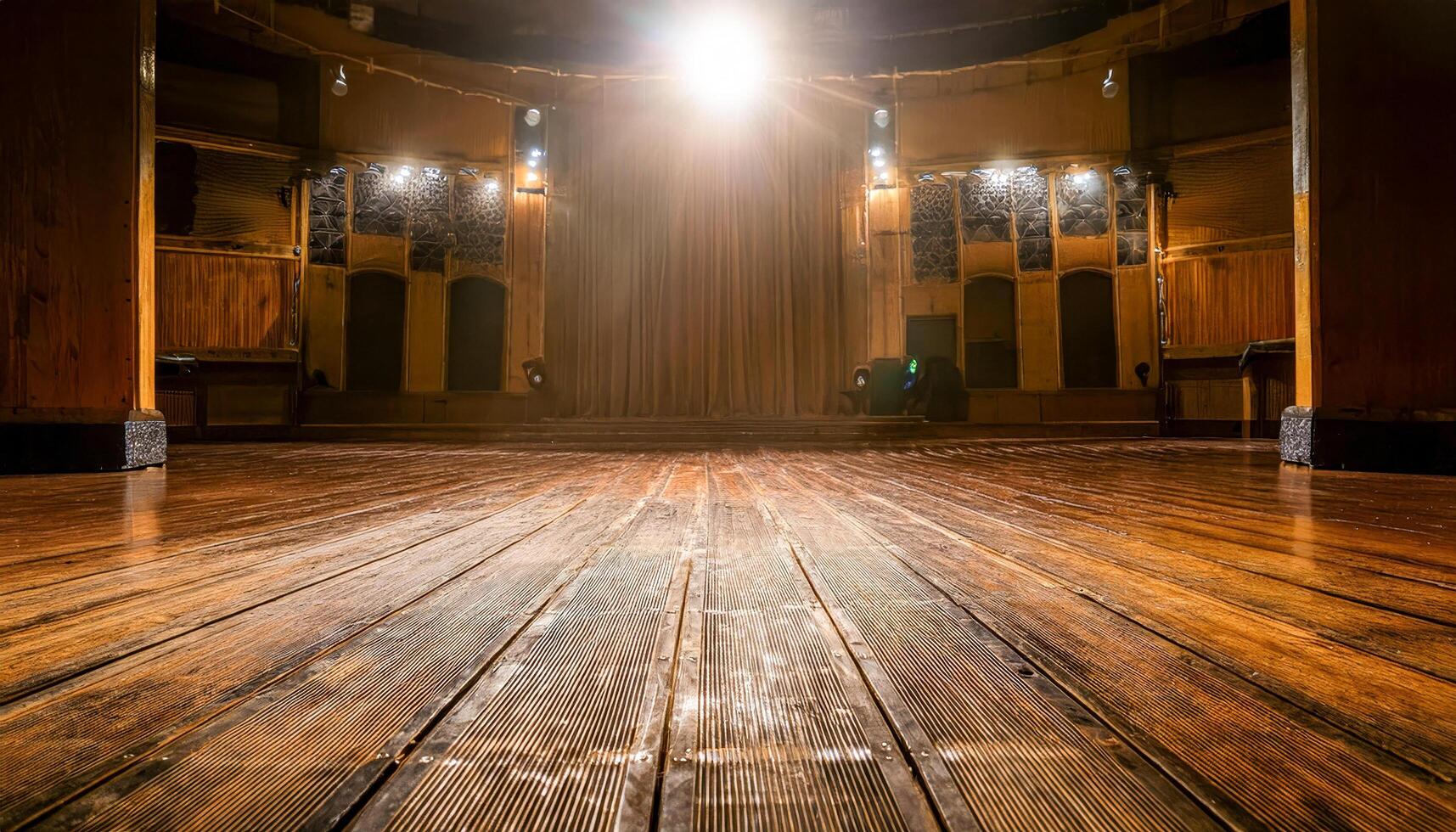 Beneath towering rafters, a beam of bright light pours onto the bare wooden floor. The darkened backdrop frames the stillness, echoing a sense of readiness and the magic of the unseen. photo