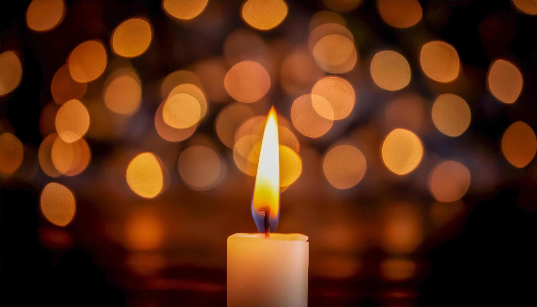 Single candle flame burning brightly against a blurred background of warm golden bokeh lights. Evokes a sense of peace, warmth, and remembrance. photo