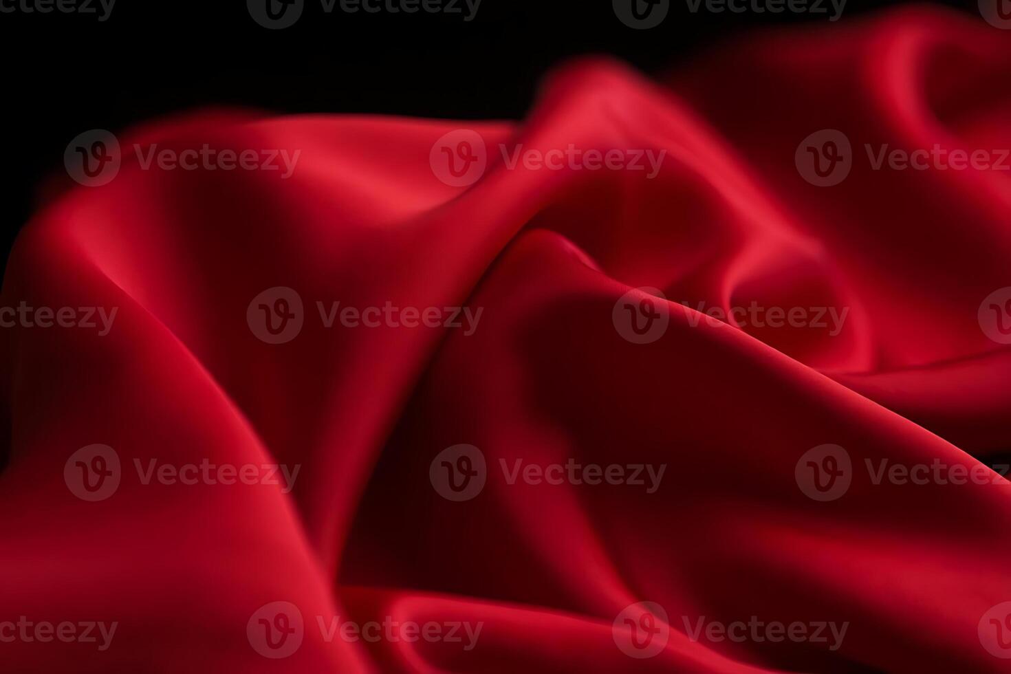 Luxurious red silk fabric in elegant waves against a black background showcasing soft folds and rich textures photo