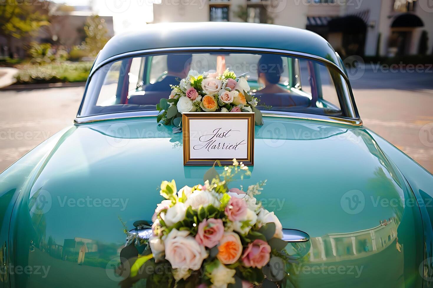Romantic photograph of a turquoise classic car decorated with flowers and a just married sign for a wedding celebration photo