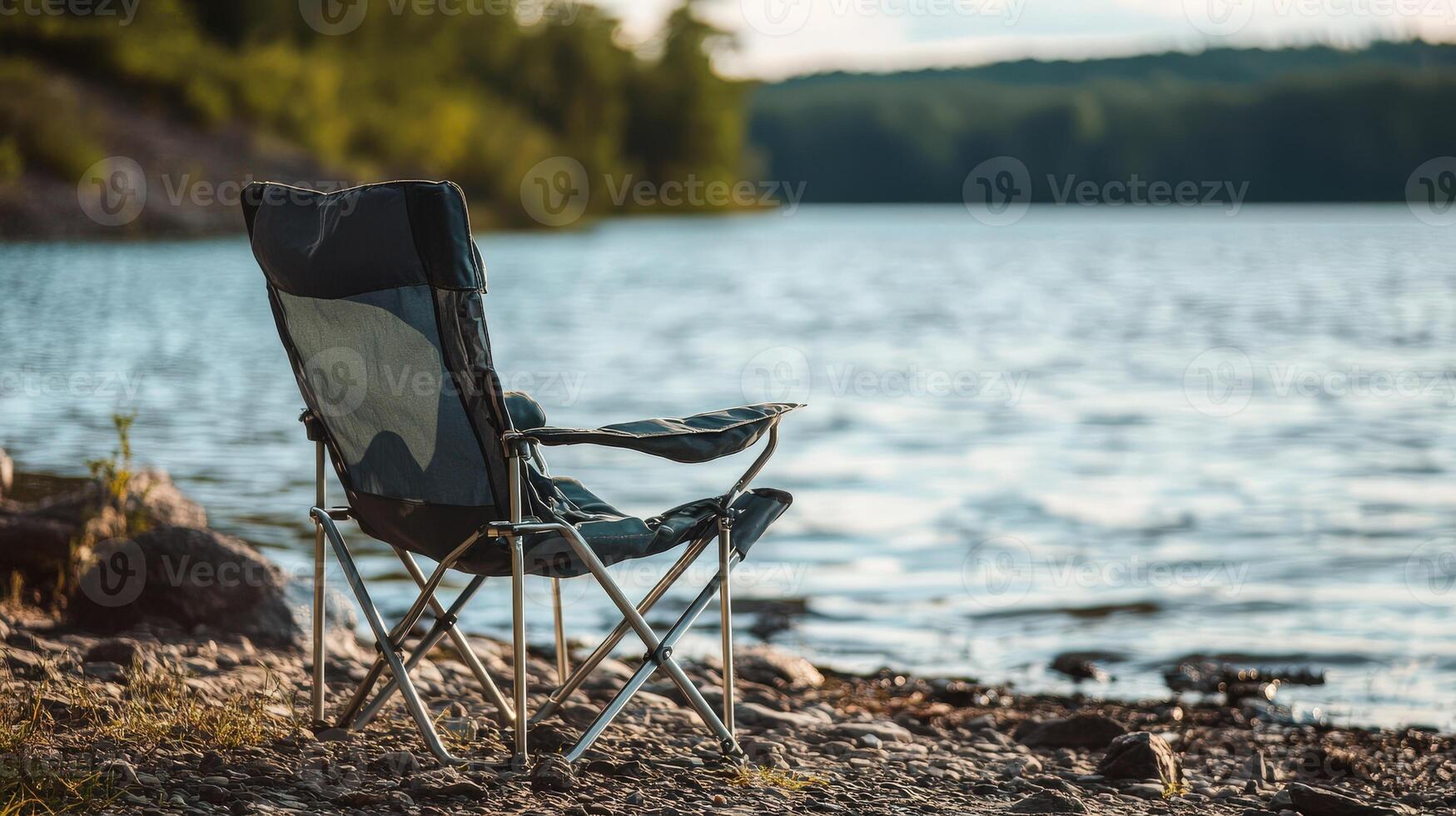 Empty folding chair by a tranquil lake shore. photo