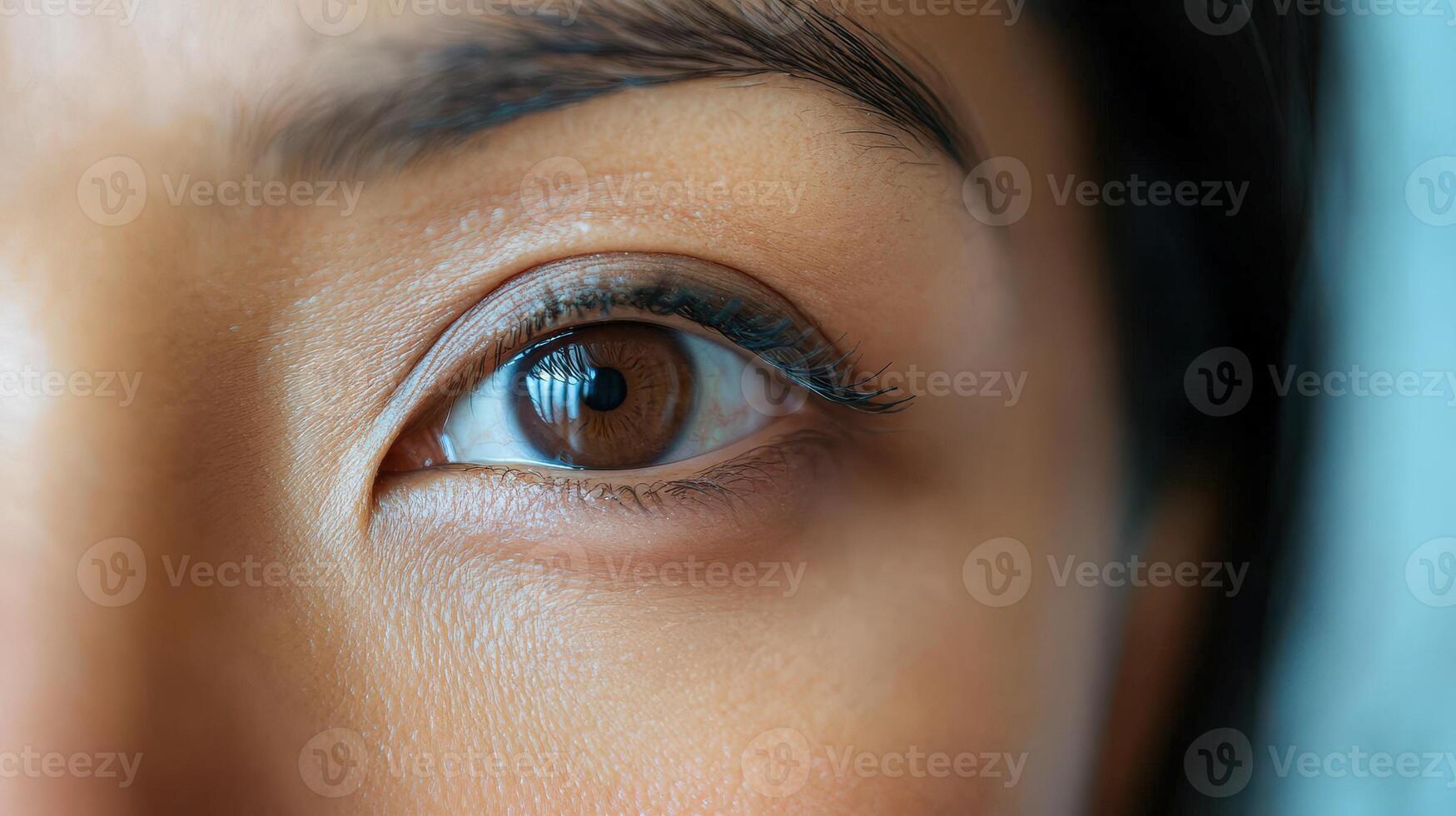 Close-up view of a person's brown eye and surrounding facial area. photo