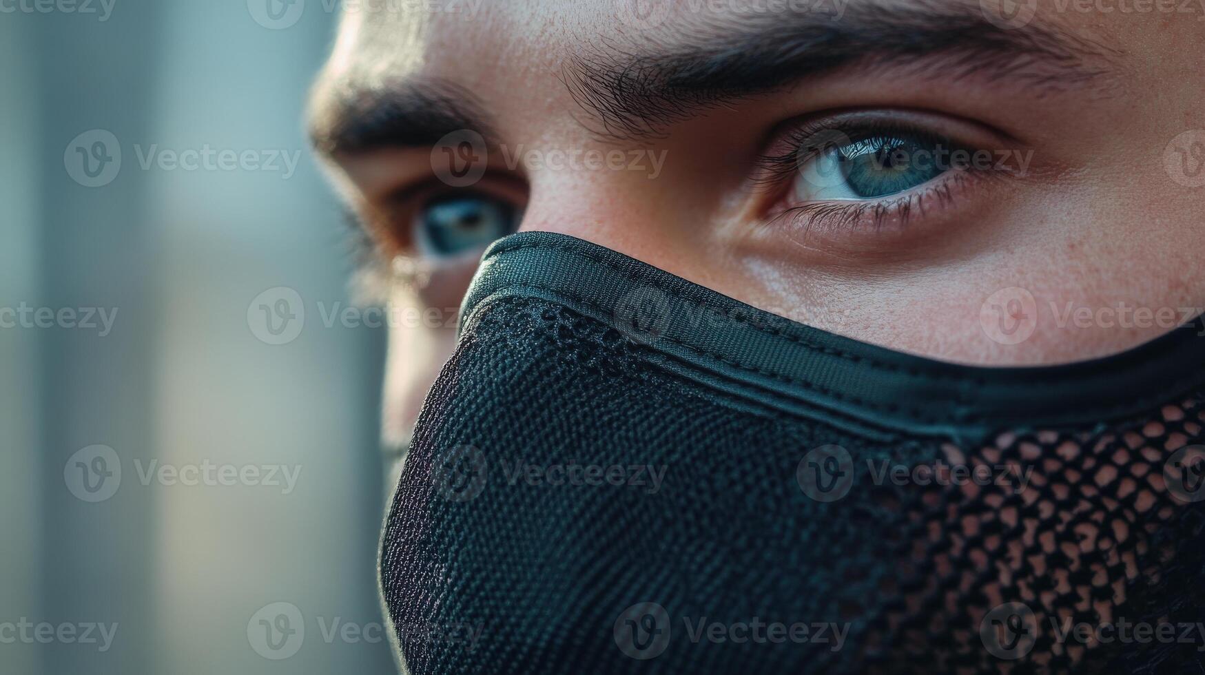 Close-up profile view of a person wearing a dark face mask. photo