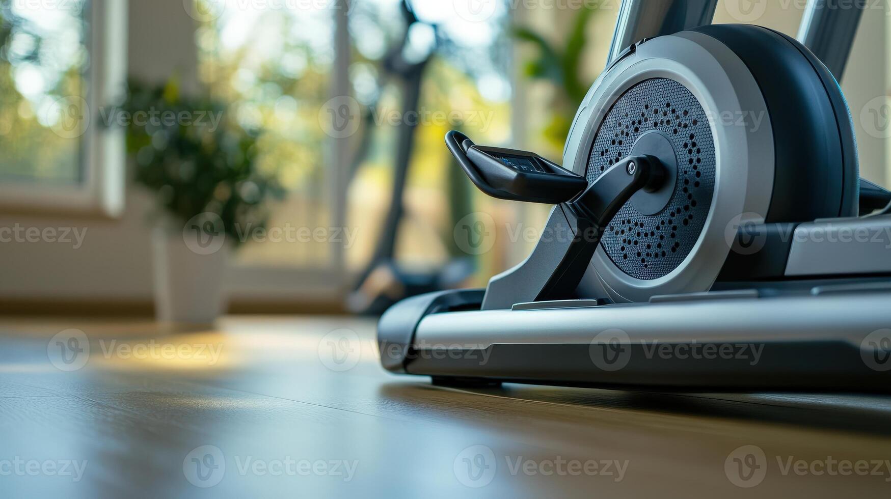 Elliptical machine detail with a blurred view of the background indoors photo