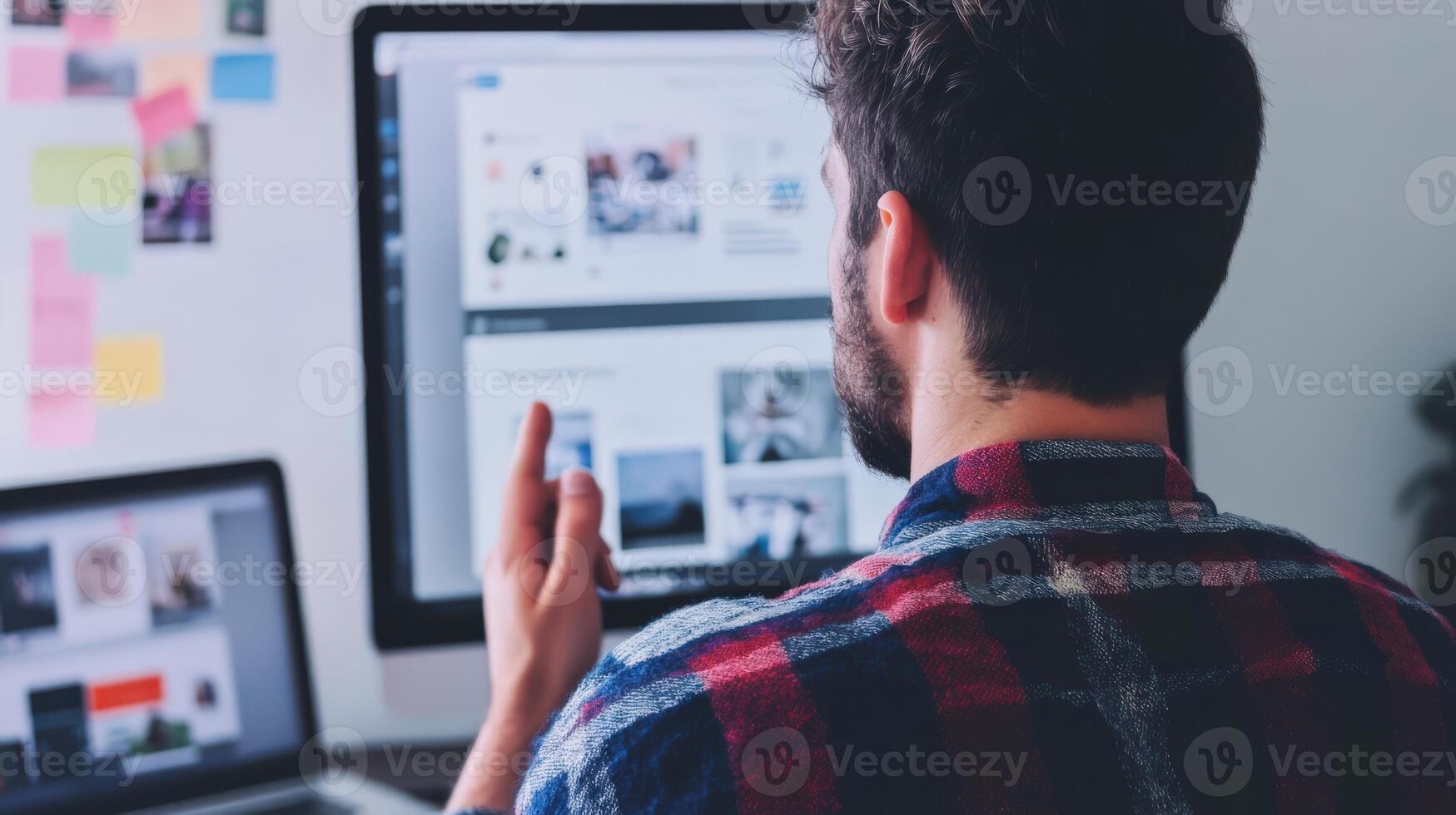 Focused individual reviewing digital images on multiple screens. photo