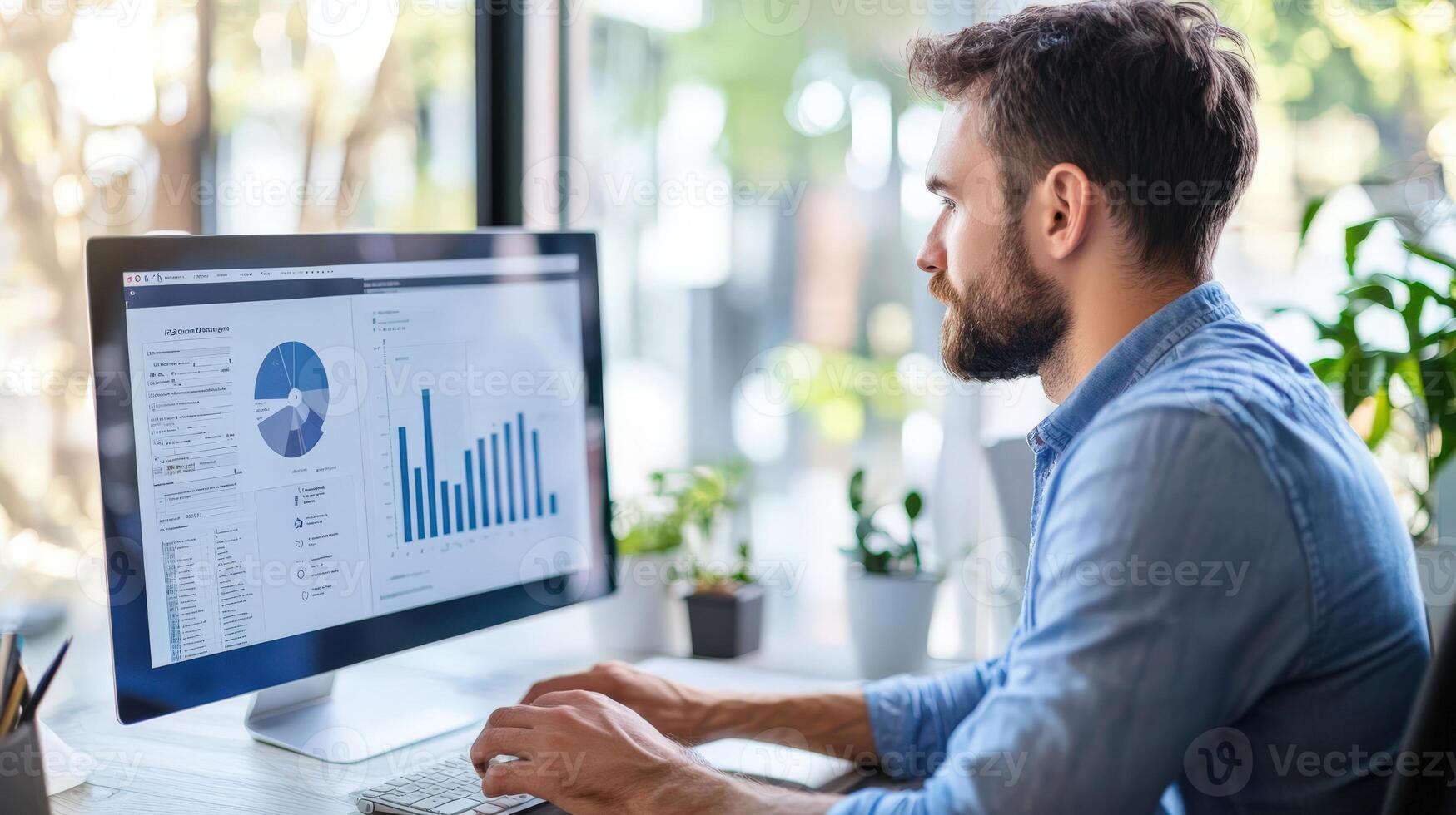 Focused man reviewing business data on a computer. photo