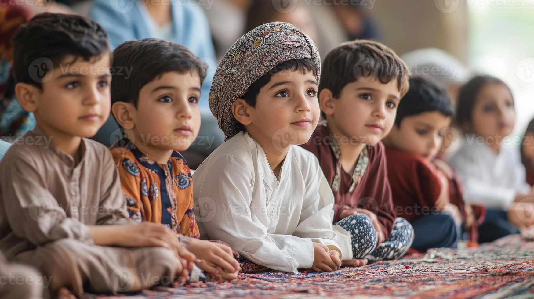 Attentive young children seated on a patterned floor. photo