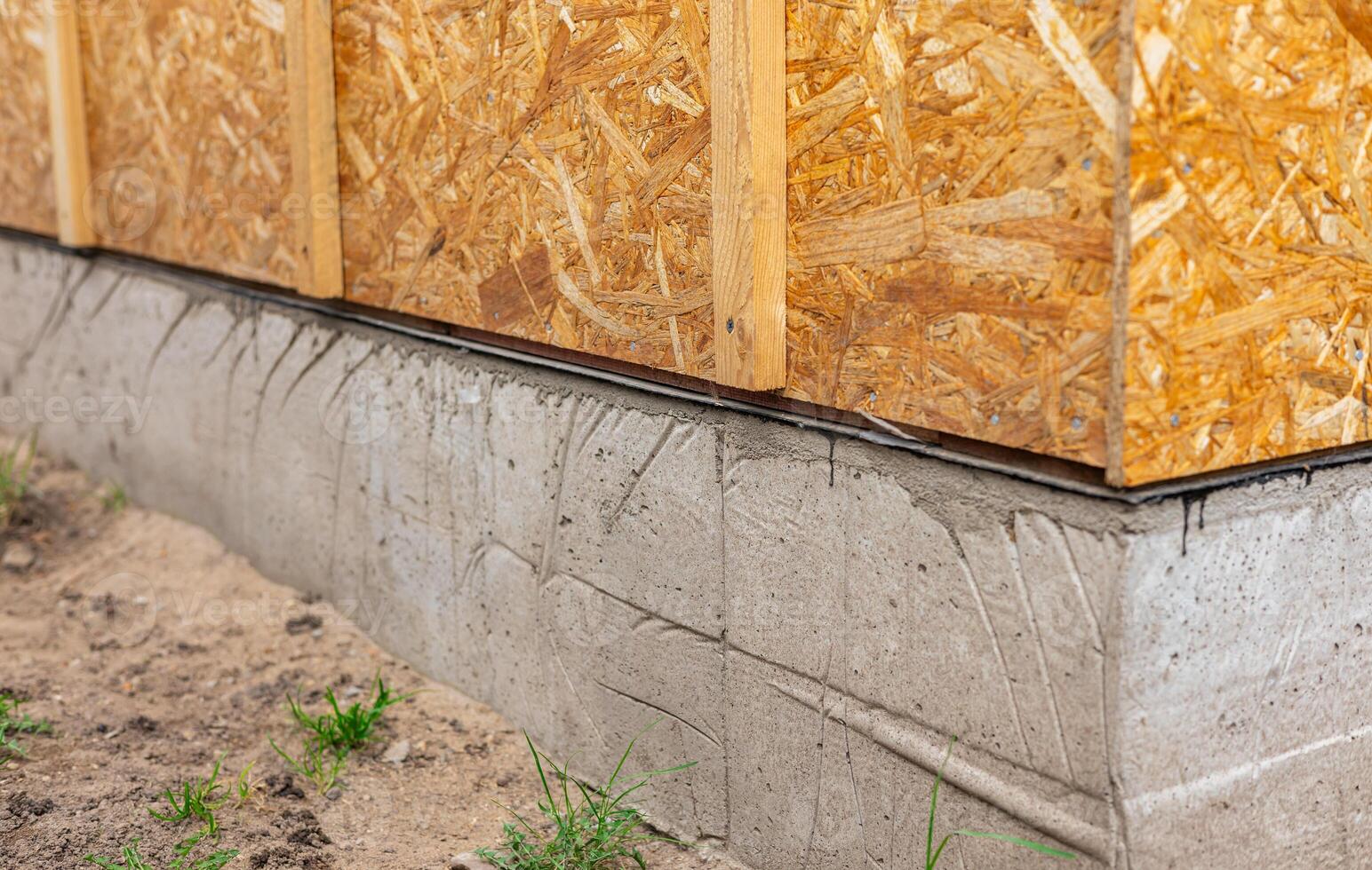 Plywood sheets on a concrete foundation, installation of OSB wall panels. photo