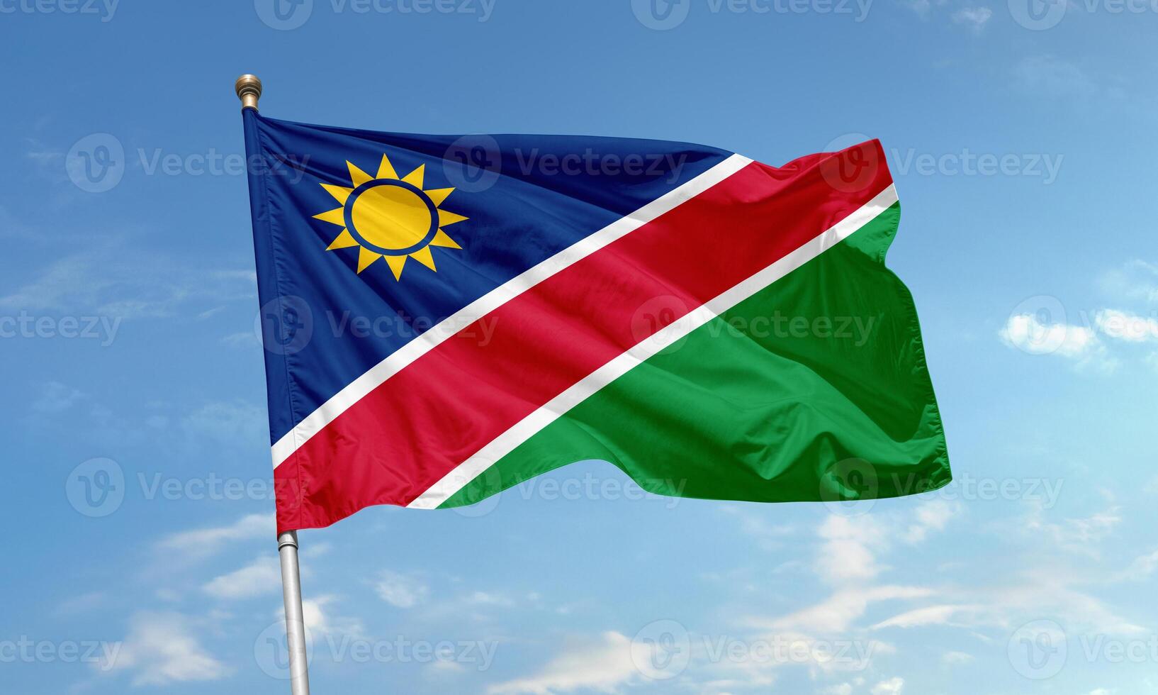 Waving flag of Namibia with diagonal tricolor and golden sun symbol photo