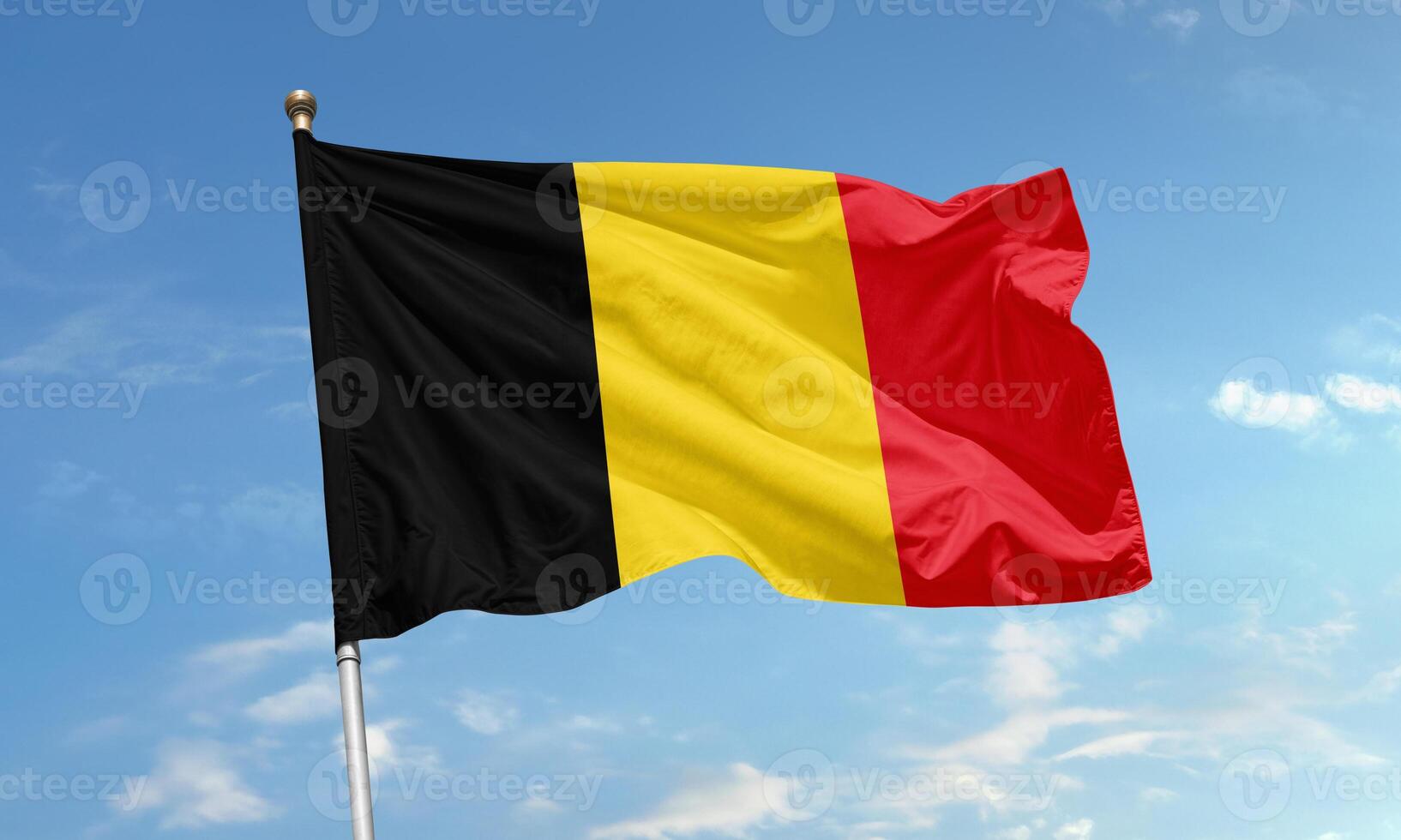 Belgium national flag with vertical black, yellow, and red stripes symbolizing unity and strength under a clear blue sky photo