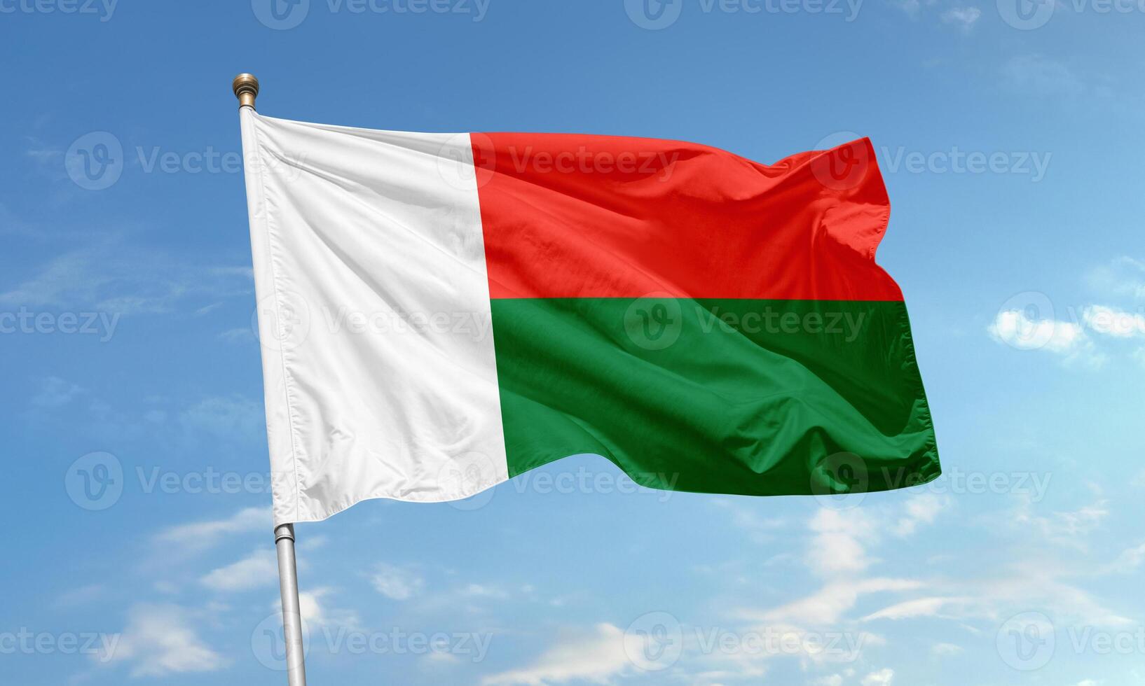 Madagascar national flag with red, green and white colors waving against a clear blue sky photo