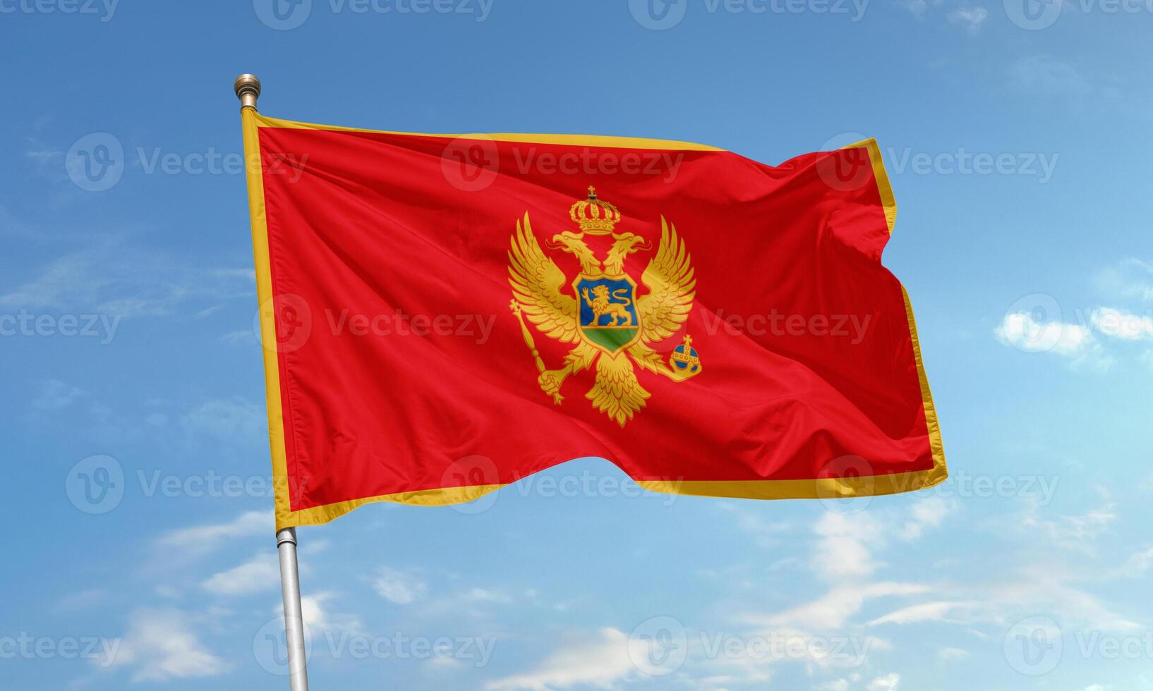 Montenegro national flag with golden border and eagle emblem waving proudly in the sky photo