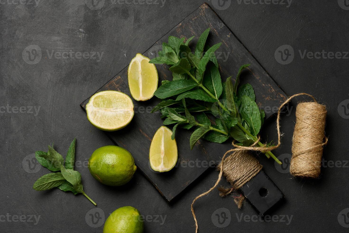 Bunch of fresh green mint and lime wedges on wooden board photo