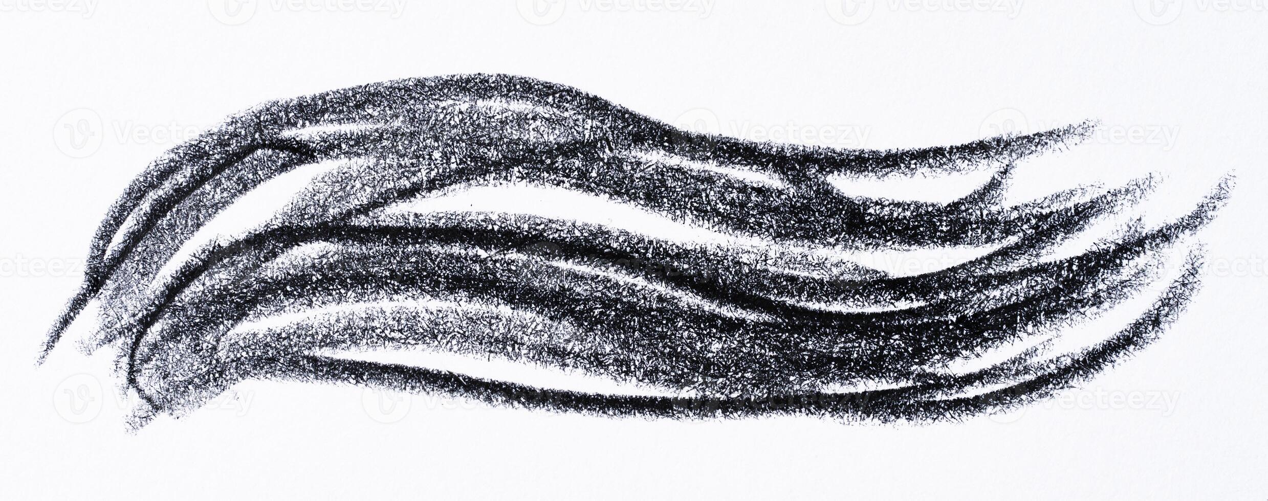Close up of a wavy black pencil or charcoal stroke on an isolated background. photo