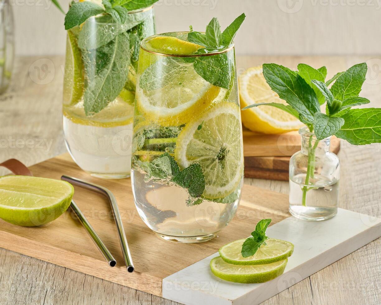 Refreshing citrus and mint drink in glasses with ice, lemon, lime, and mint leaves photo
