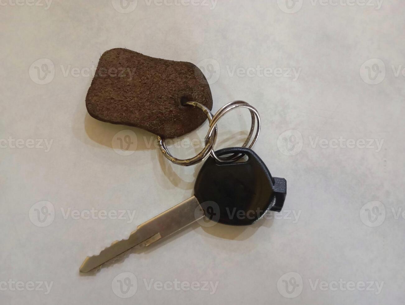 Motorbike Key with Simple Keychain. A basic motorbike key attached to a leather brown keychain. photo