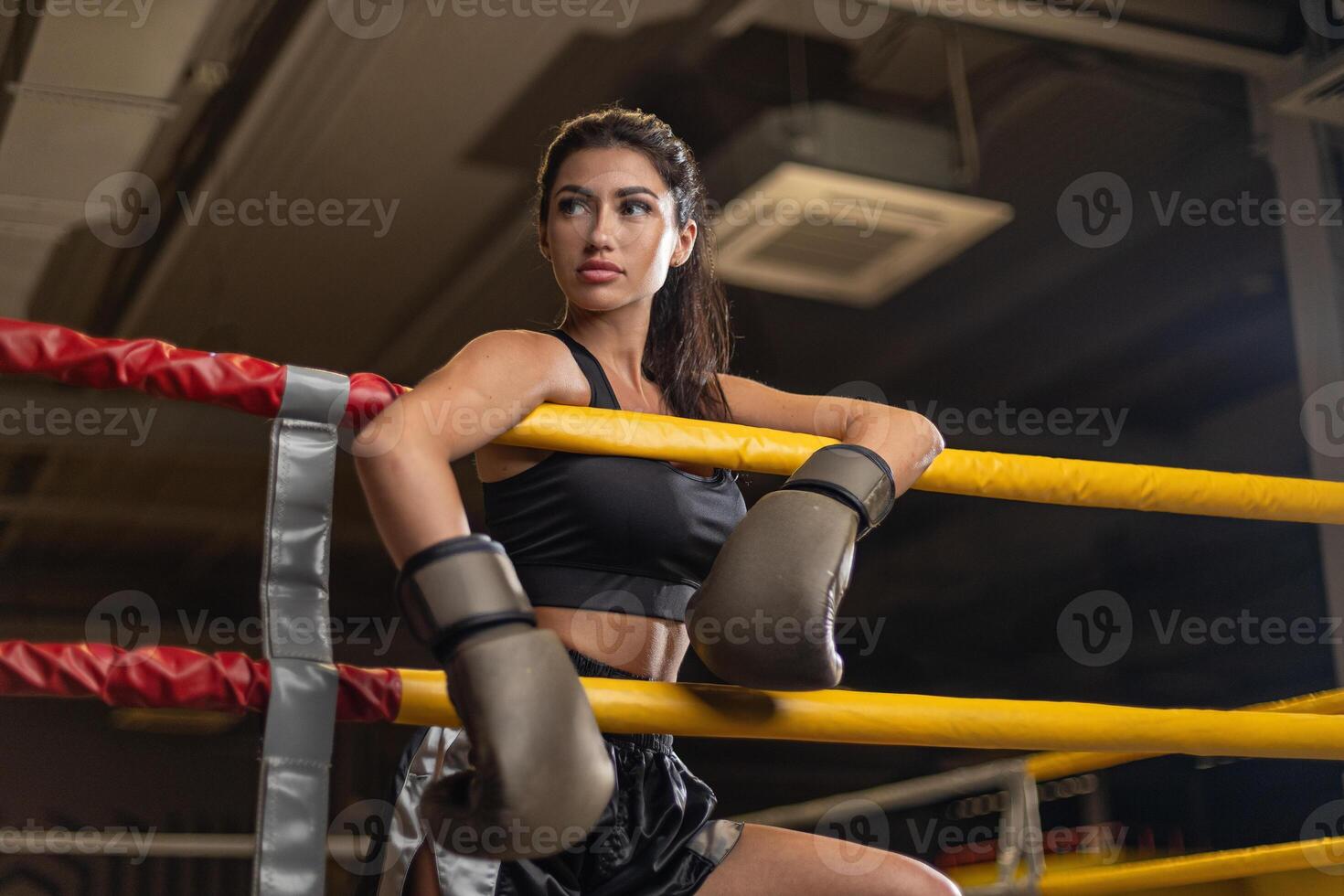 Female boxer posing with confidence in training gym during afternoon workout session photo