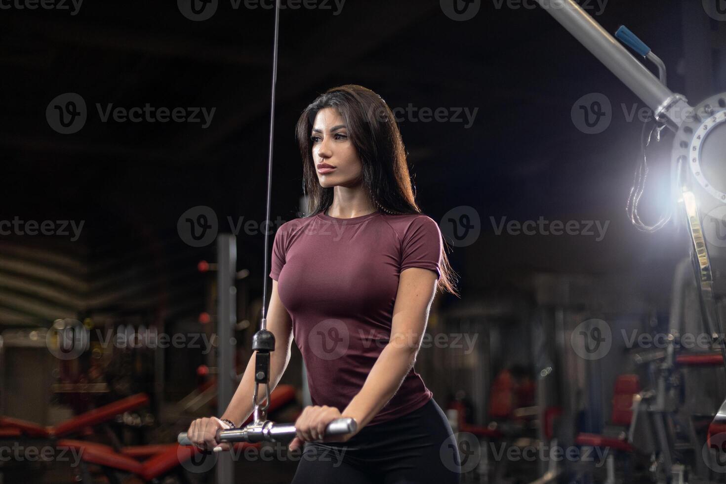 Woman training with cable machine in modern gym focused on fitness and strength building photo