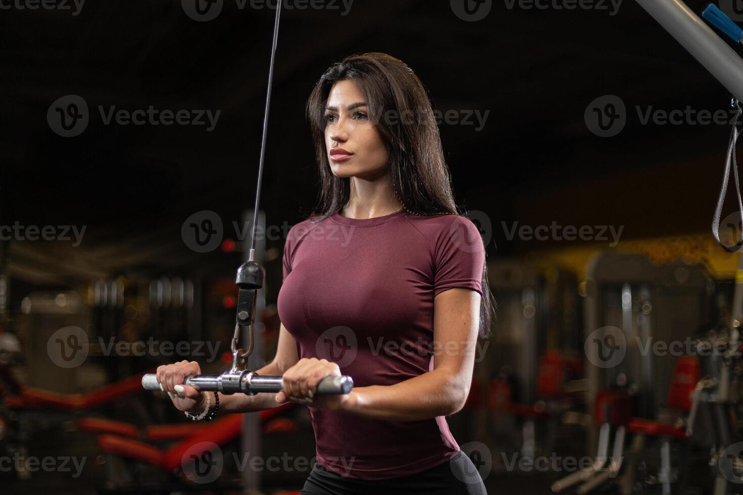 Fitness enthusiast performs cable workout in gym during evening session for strength training and muscle development photo