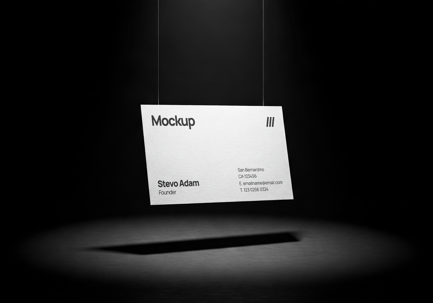 Hanging business card mockup in a dark minimal scene with dramatic spotlight and shadow beneath psd