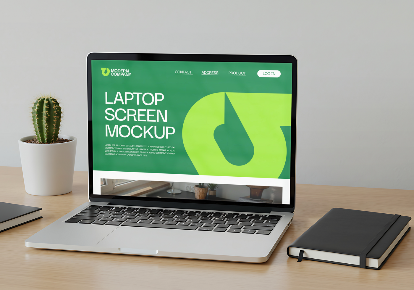 A laptop displaying a website mockup sits on a desk beside a cactus and notebook psd