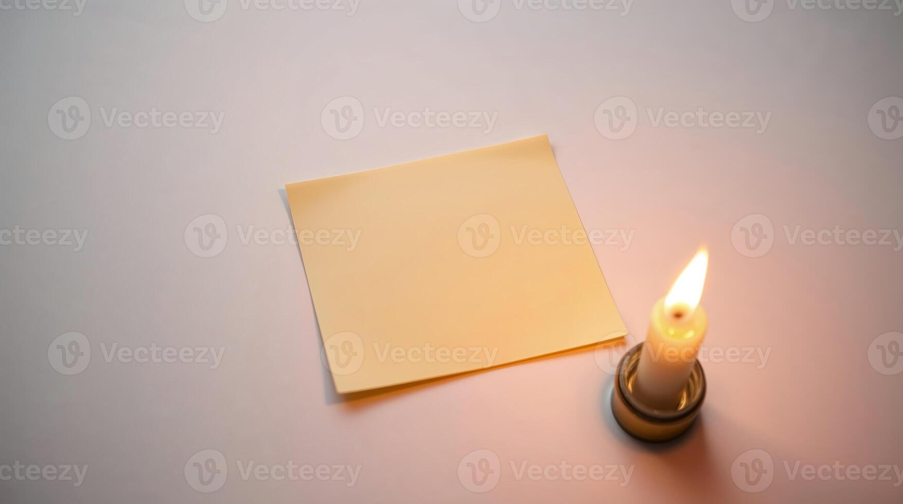 A high-angle shot of a sticky note lit by candlelight, with gentle flickering light and a warm glow. photo