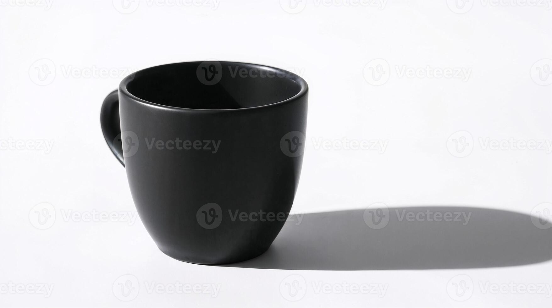 Close up photograph of a matte black coffee cup on a white background. Strong shadows define the cups form, focusing on texture and detail in a minimalist still life style. photo