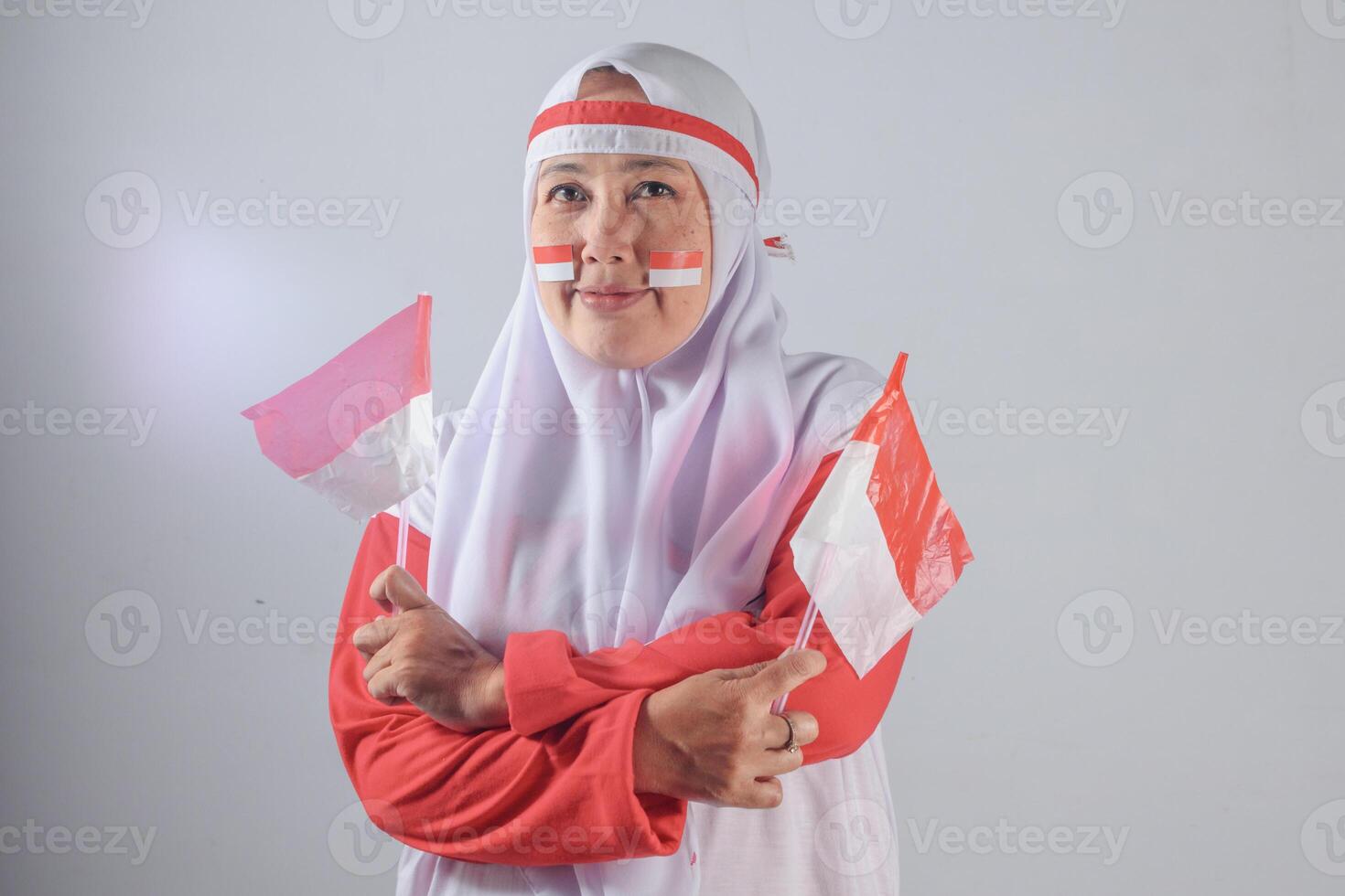 Proud Indonesian Muslim Woman Holding Flags to celebrate independence and express national pride in a traditional cultural portrait photo session