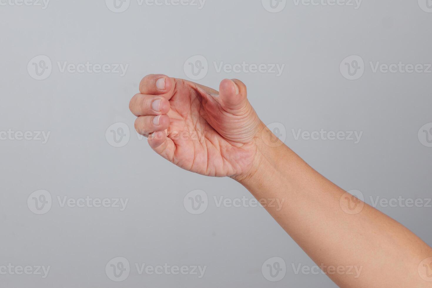 Curved human hand forming holding gesture with fingers bent inward and thumb extended suggesting grip motion, readiness to grasp or take, captured on neutral background photo