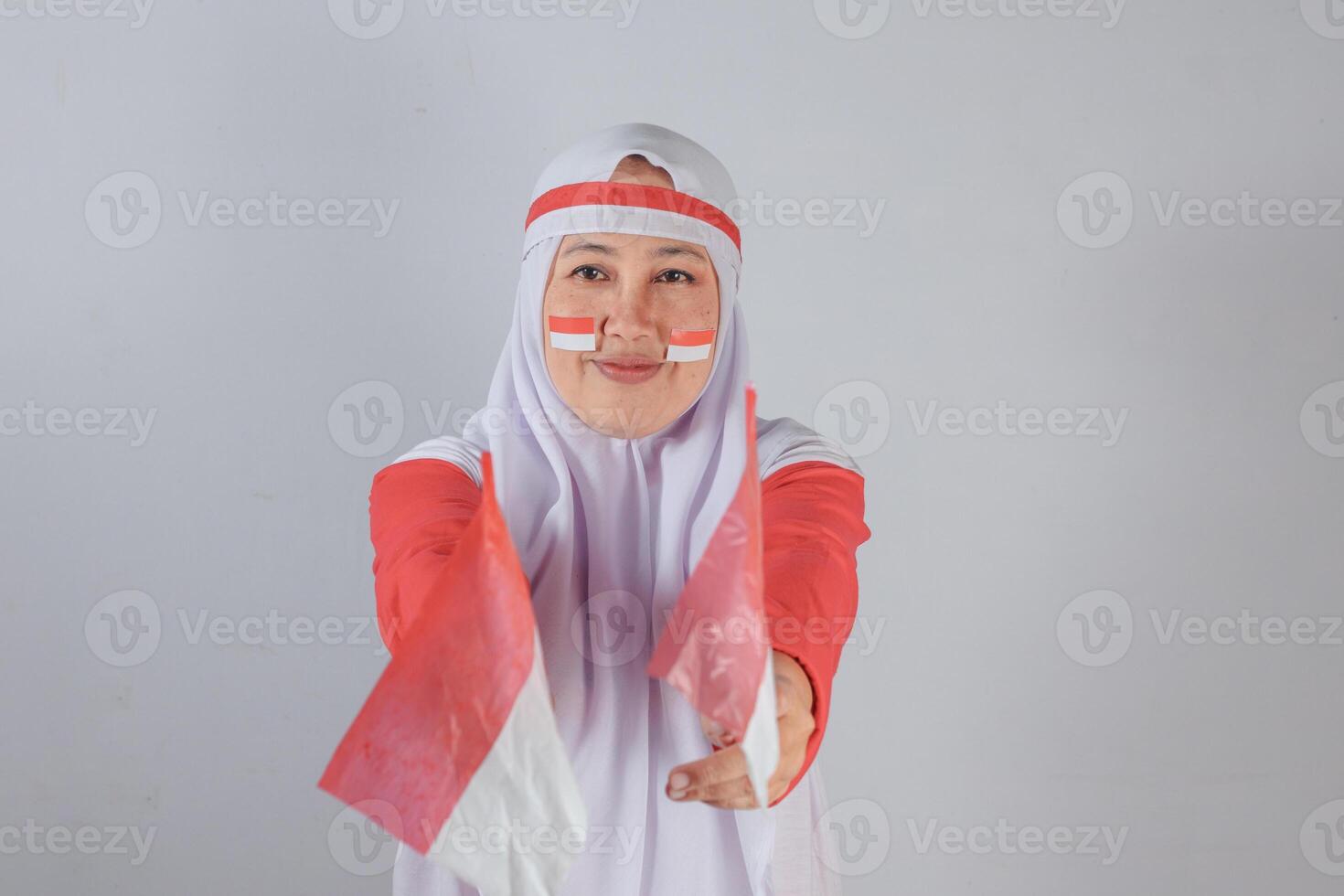 Confident muslim woman holding two national flags forward with smile during independence celebration photo