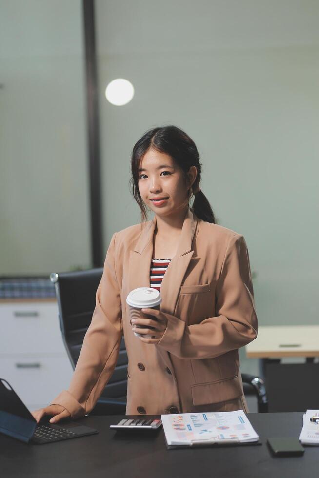 Asian businesswoman holding coffee cup in office photo
