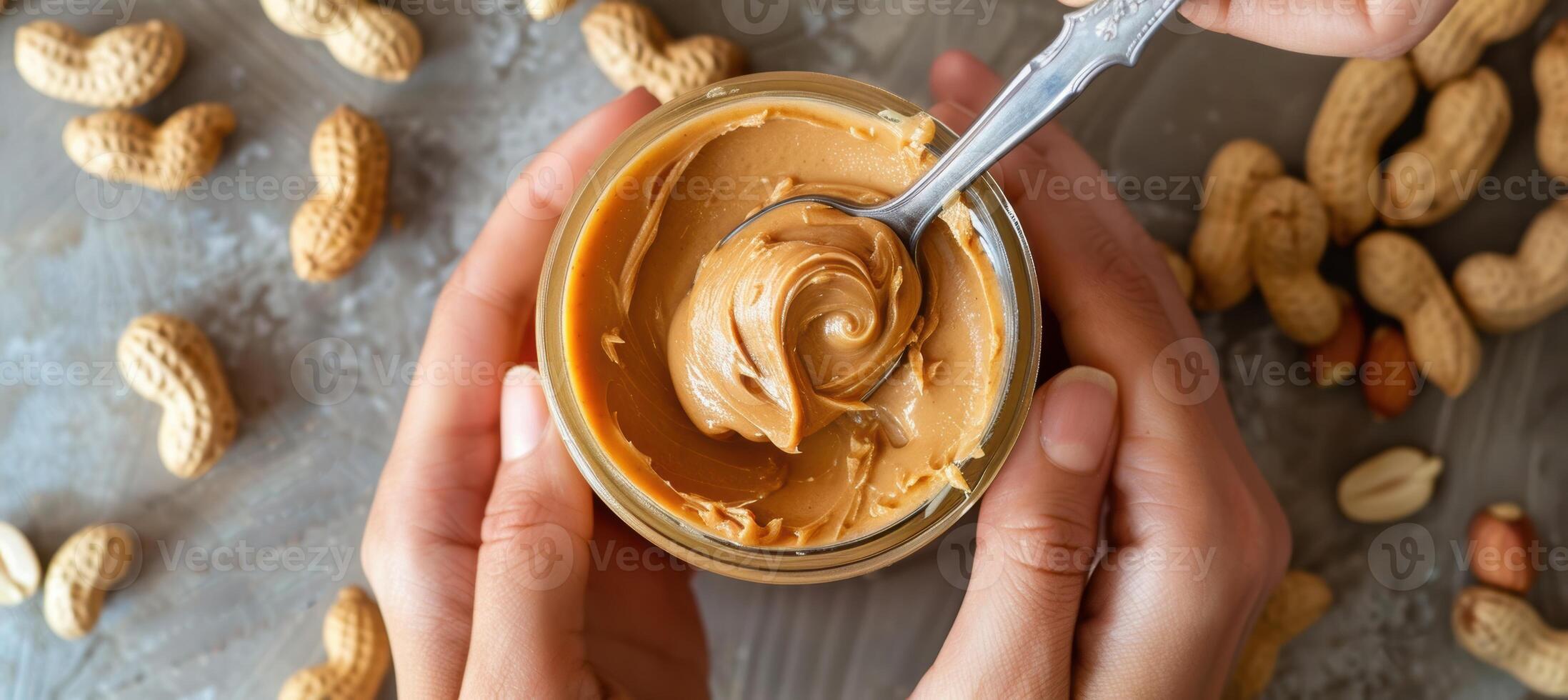 Close-Up of Hands with Peanut Butter Jar and Spoon for Food Photography and Cooking Inspiration photo