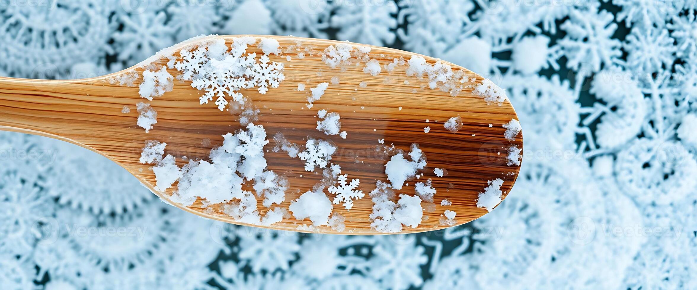 wooden spoon filled with snow on top of snow covered ground photo