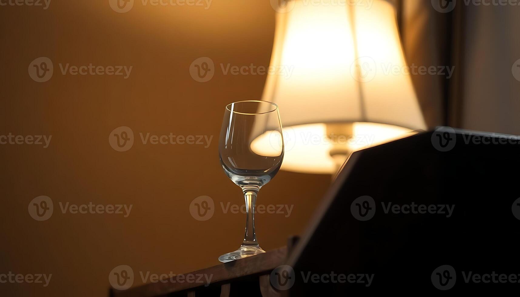 wine glass sitting on a table next to a lamp photo