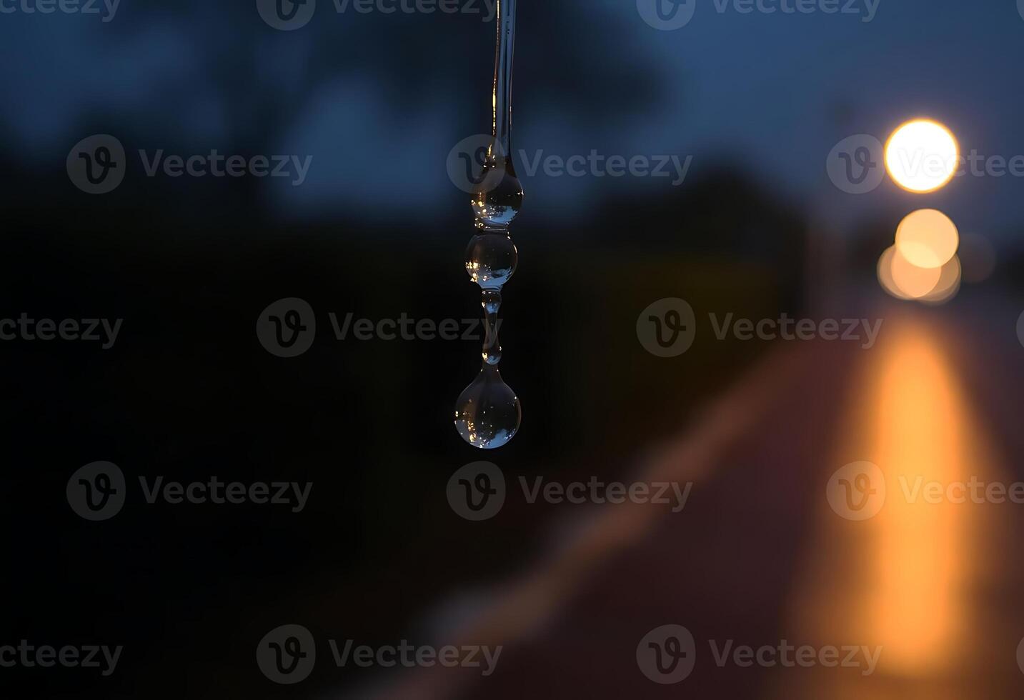 drop of water hanging from the side of a road photo